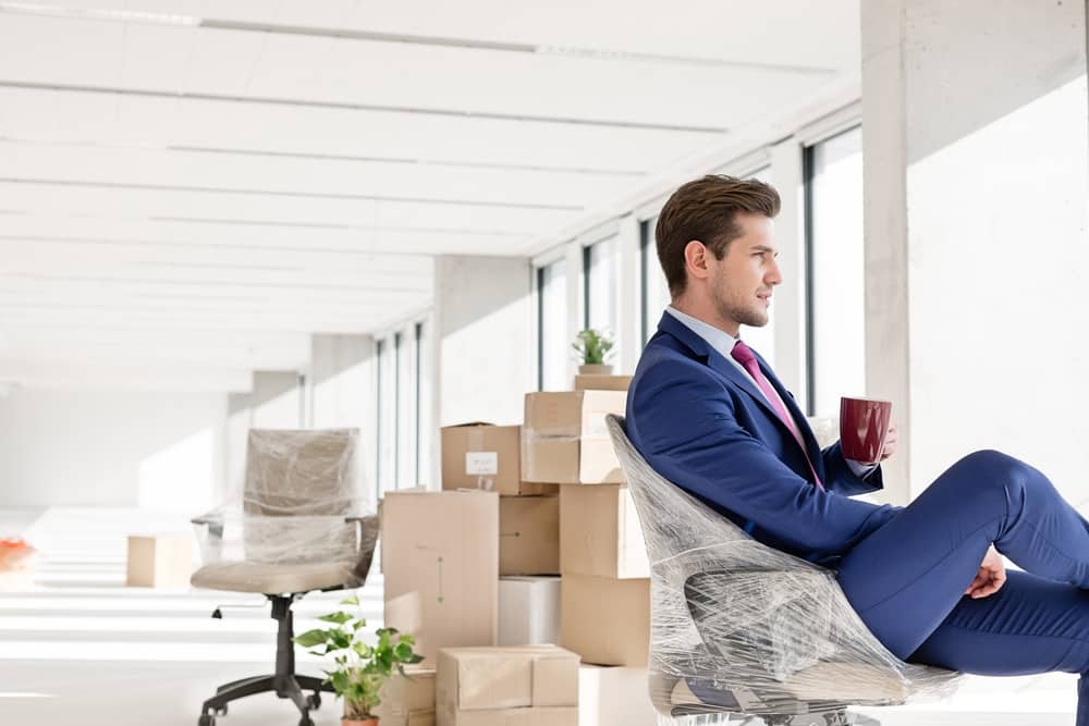 Side,View,Of,Young,Businessman,Having,Coffee,On,Chair,In