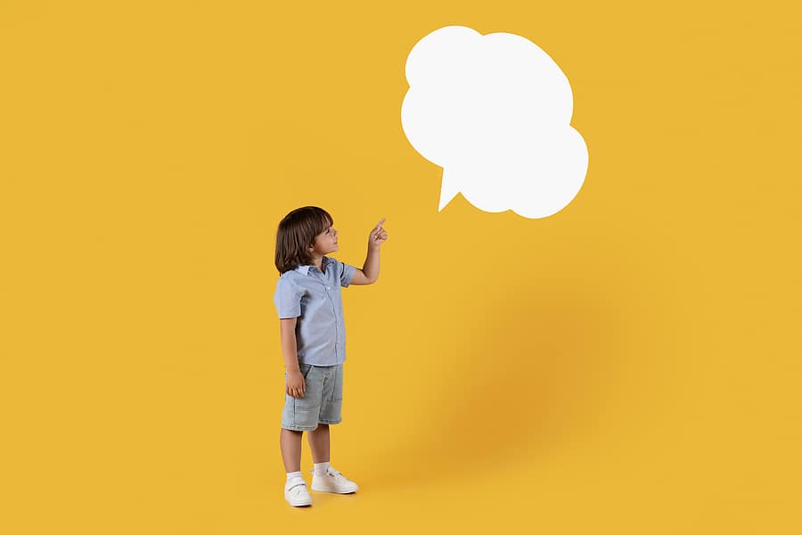 Boy looking at blank speech bubble