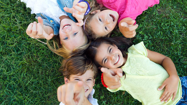 Kids smiling and pointing at camera