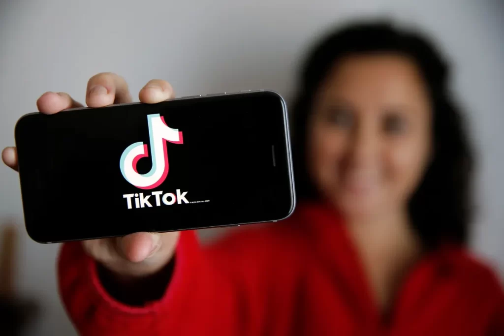 Girl holding phone with TikTok