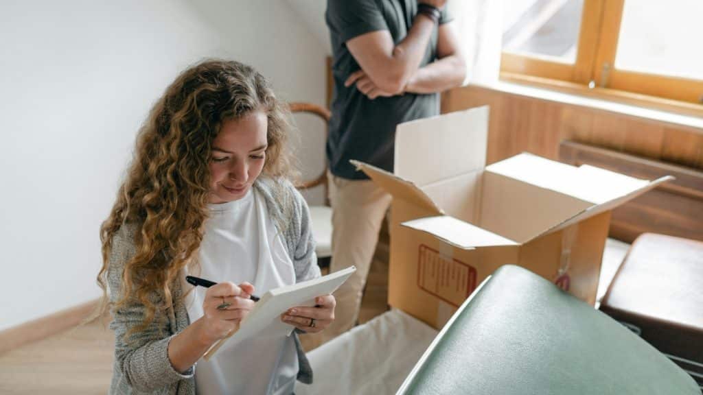 A woman creating a checklist before touring local moving company warehouses