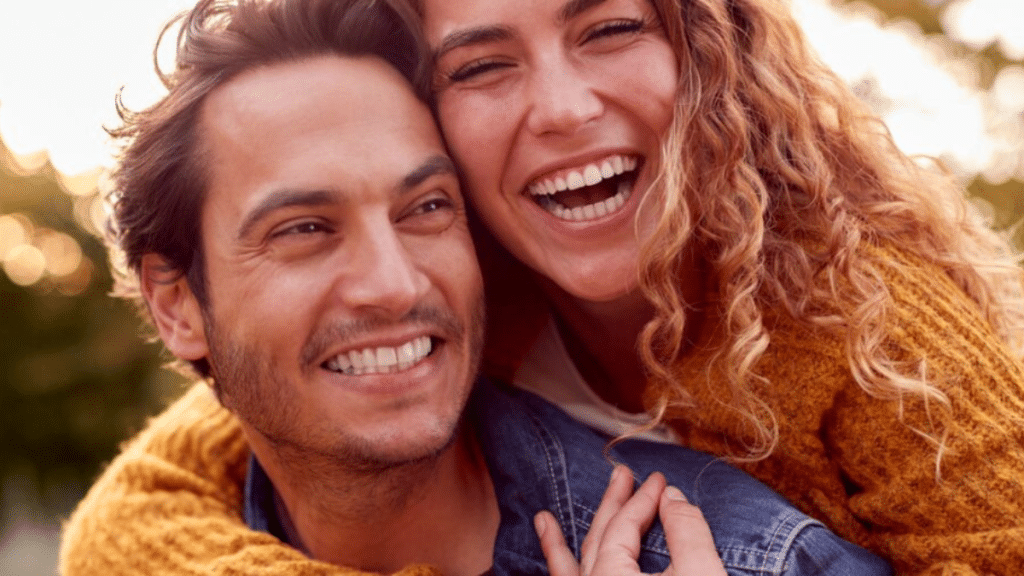 woman-sitting-on-partners-lap-holding-condom-to-practise-safe-sex-and-support-sexual-health