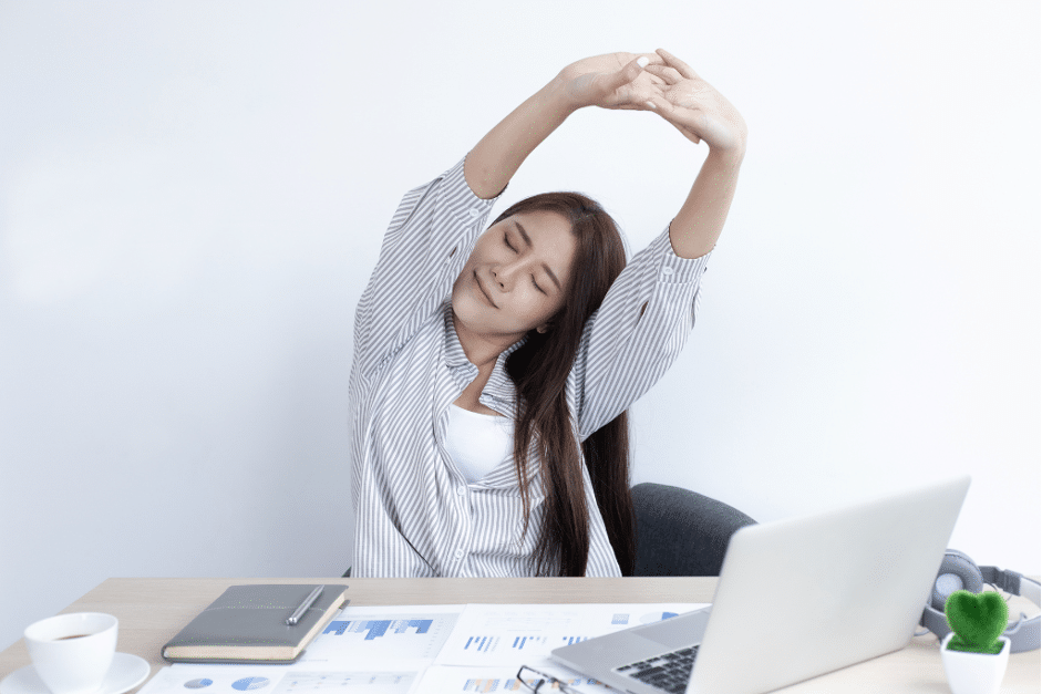 woman-stretching-arms-at-desk-to-relieve-neck-and-shoulder-tension-during-computer-break