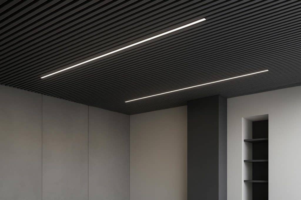 Transforming High-End Spaces with Wood and Metal Linear Ceiling Systems Metal linear ceilings in a contemporary interior, showcasing modern architectural design trends